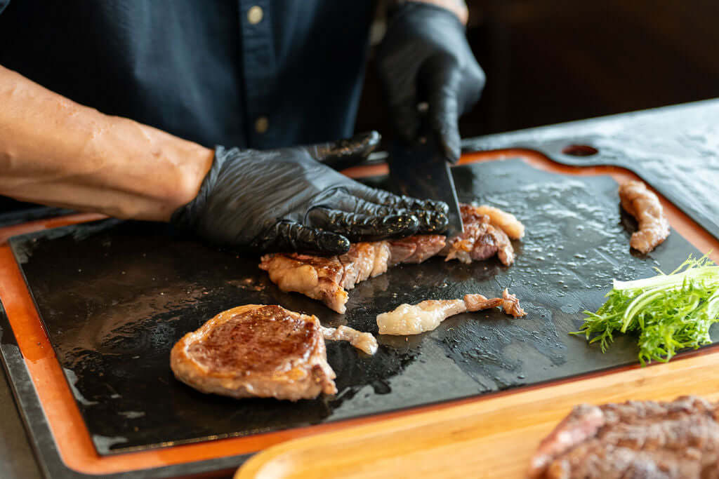 Live station BBQ chef grilling on deck of a Yacht Maison yacht in Singapore